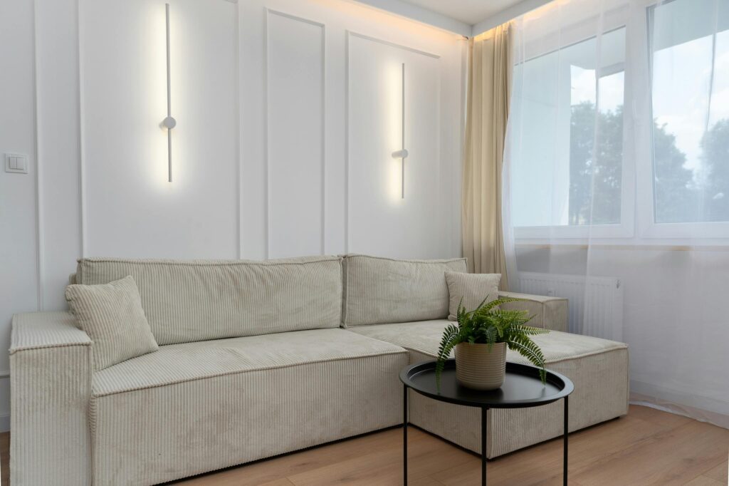 Elegant minimalist living room featuring a beige sofa and modern lighting, Kraków.
